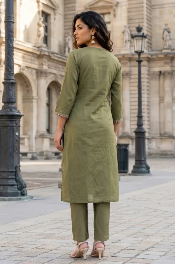 Woman in olive green kurta and pants standing on a historic European street.